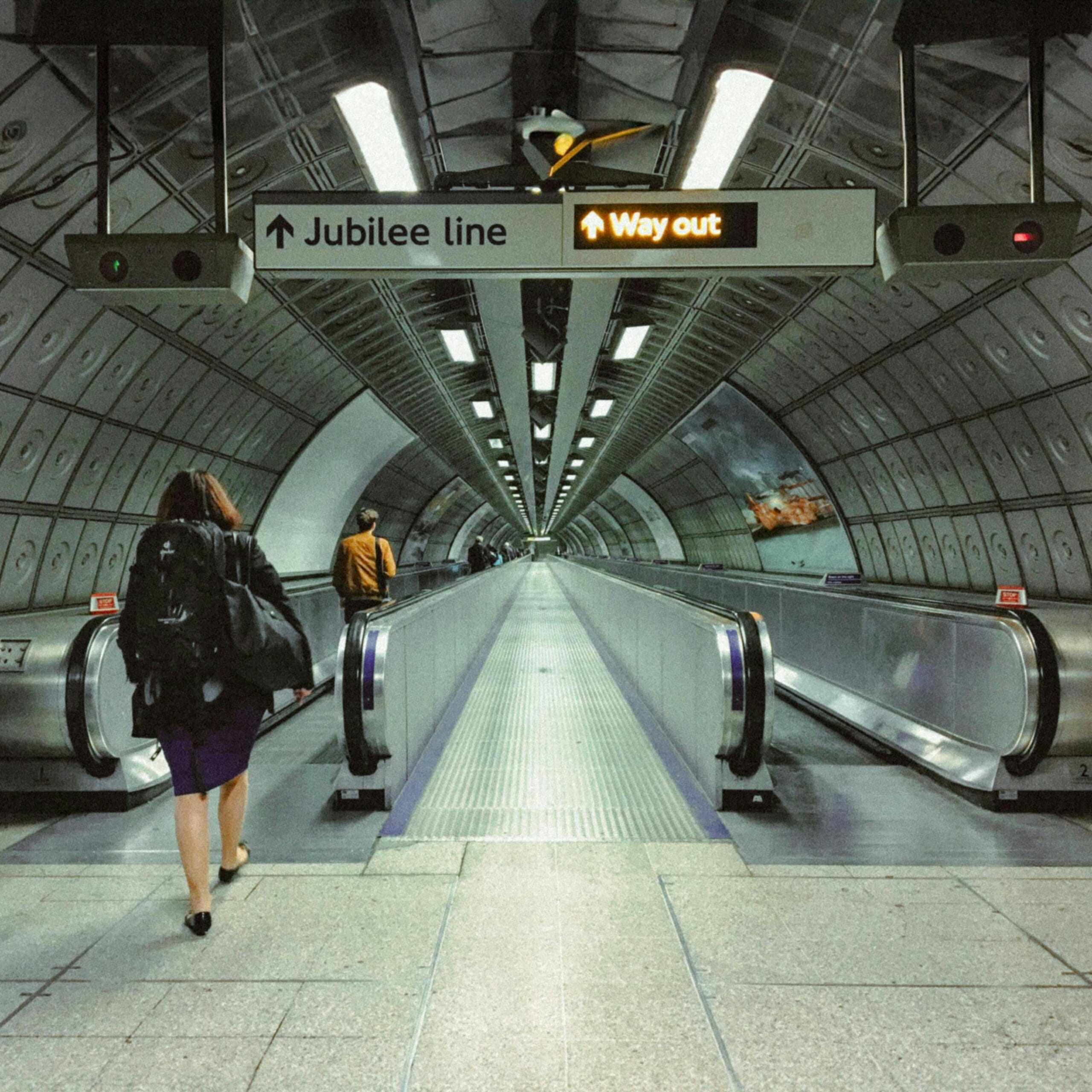 Commuters in a futuristic London subway tunnel on the Jubilee Line.